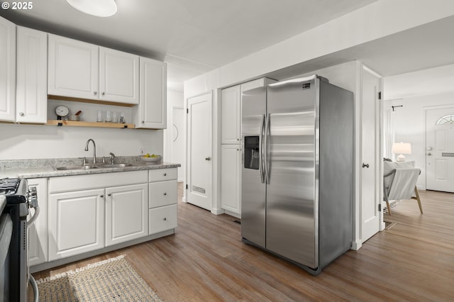 kitchen with white cabinetry, sink, hardwood / wood-style flooring, and appliances with stainless steel finishes