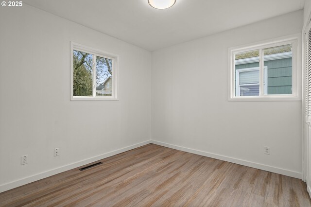 unfurnished room with plenty of natural light and light hardwood / wood-style flooring