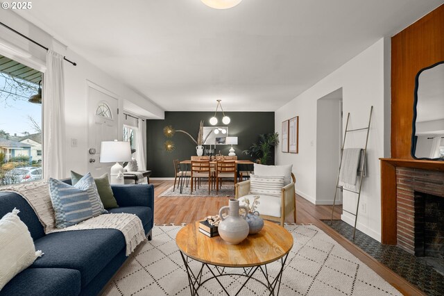 living room with a brick fireplace and light hardwood / wood-style floors