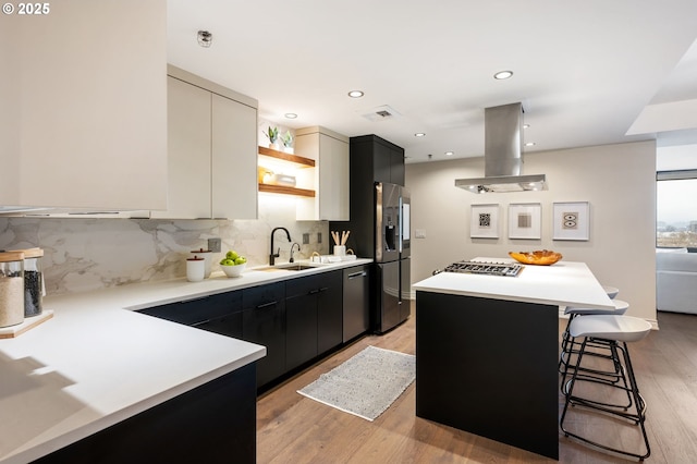 kitchen featuring sink, a kitchen bar, island exhaust hood, a center island, and stainless steel appliances