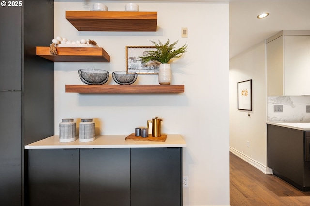 bar featuring decorative backsplash and hardwood / wood-style floors