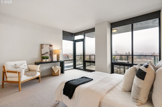 bedroom featuring access to outside, floor to ceiling windows, and carpet