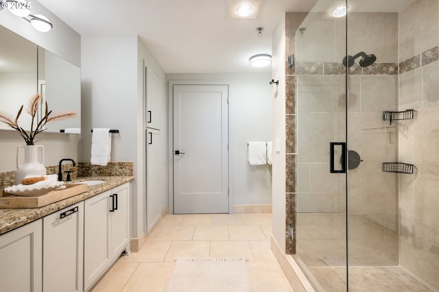 bathroom featuring vanity, a shower with shower door, and tile patterned flooring