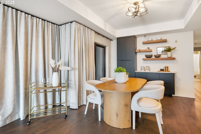 dining area featuring dark wood-type flooring and a notable chandelier