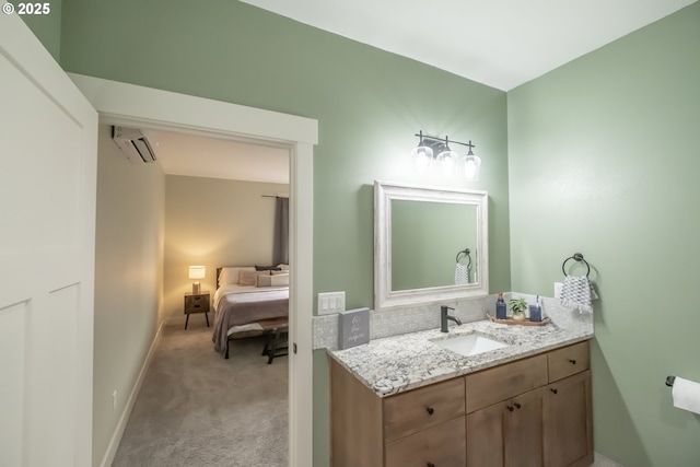 bathroom featuring a wall unit AC and vanity