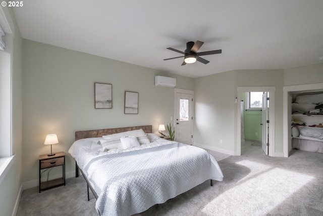 carpeted bedroom featuring ceiling fan and a wall mounted air conditioner