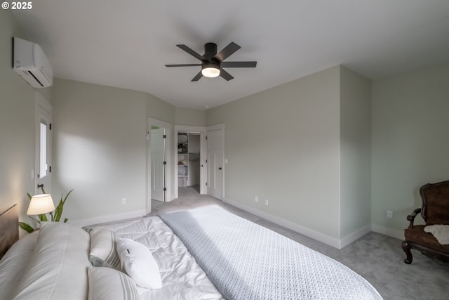 bedroom featuring a walk in closet, light carpet, a closet, a wall mounted AC, and ceiling fan