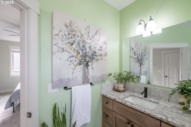 bathroom featuring ceiling fan, vanity, and tasteful backsplash