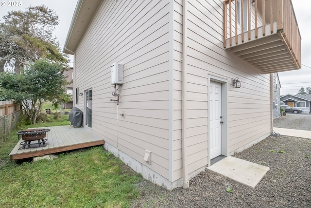 view of side of home with an outdoor fire pit and a deck