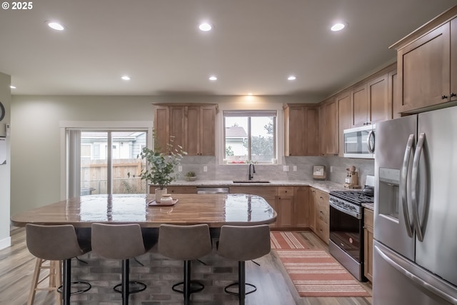 kitchen featuring stainless steel appliances, backsplash, a center island, and sink