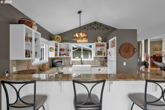 6027 View Loop, Florence, OR 97439 - kitchen featuring open shelves, fridge, tasteful backsplash, stone counters, and vaulted ceiling