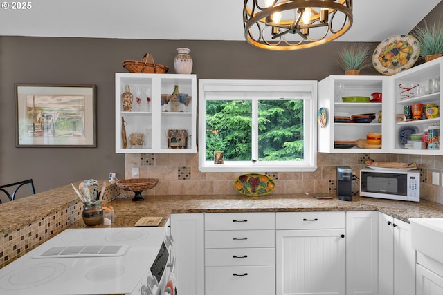 6027 View Loop, Florence, OR 97439 - kitchen with white microwave, open shelves, white cabinetry, and backsplash