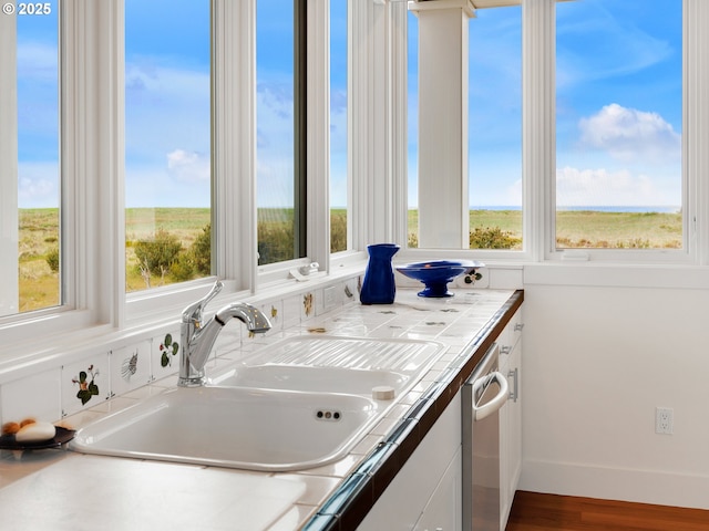 766 Neacoxie Blvd, Gearhart, OR 97138 - kitchen featuring tile counters, a sink, white cabinetry, and wood finished floors