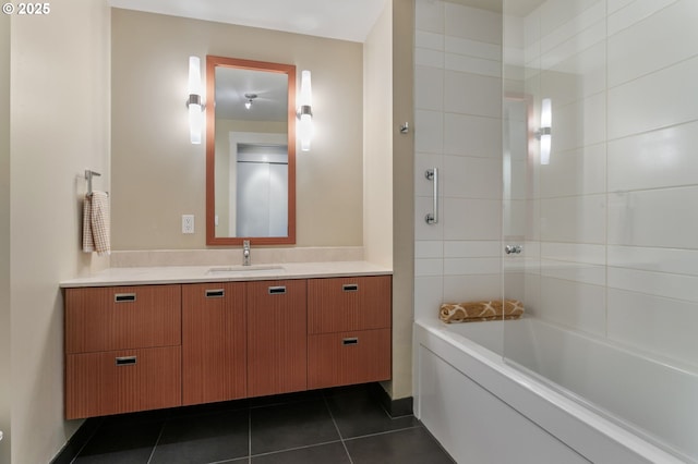 bathroom featuring tiled shower / bath, vanity, and tile patterned flooring