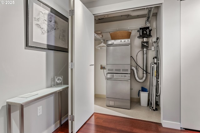 interior space with stacked washing maching and dryer and hardwood / wood-style floors