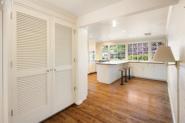 2160 Oakmont Way, Eugene, OR 97401 - kitchen with ornamental molding, light wood-style floors, a kitchen bar, stainless steel oven, and a peninsula
