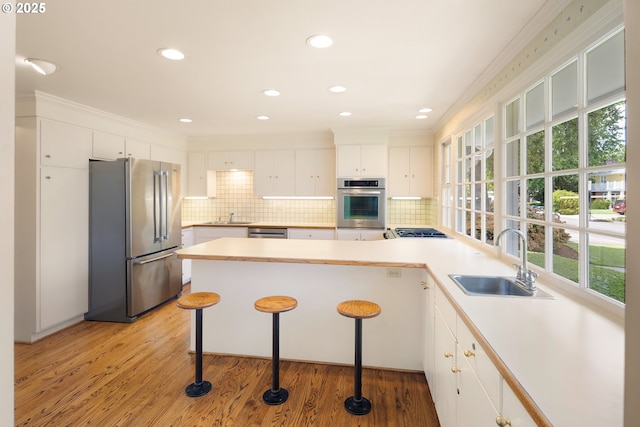 2160 Oakmont Way, Eugene, OR 97401 - kitchen with appliances with stainless steel finishes, a peninsula, healthy amount of natural light, tasteful backsplash, and crown molding