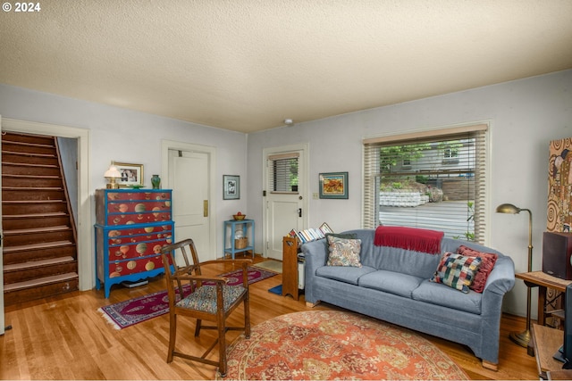 living room with a textured ceiling and light wood-type flooring