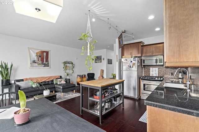 838 SE 38th Ave Unit 311, Portland, OR 97214 - kitchen with stainless steel appliances, a sink, dark wood-style flooring, backsplash, and recessed lighting