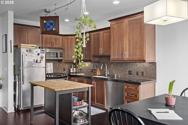 838 SE 38th Ave Unit 311, Portland, OR 97214 - kitchen with stainless steel appliances, a sink, wood counters, dark wood finished floors, and backsplash