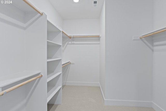 spacious closet featuring light carpet