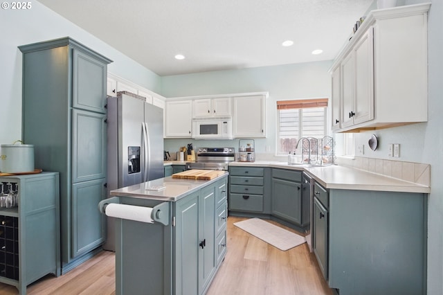 1146 SE Millright Ave, Mcminnville, OR 97128 - kitchen with appliances with stainless steel finishes, light wood-style flooring, a center island, light countertops, and a sink
