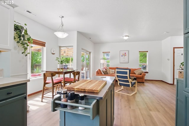 1146 SE Millright Ave, Mcminnville, OR 97128 - kitchen with light wood-type flooring, open floor plan, light countertops, pendant lighting, and baseboards