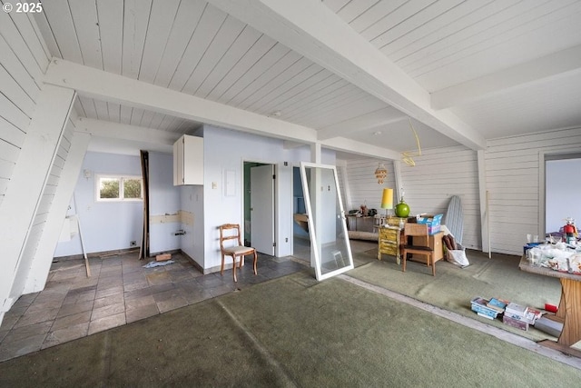 interior space with beamed ceiling and wooden walls