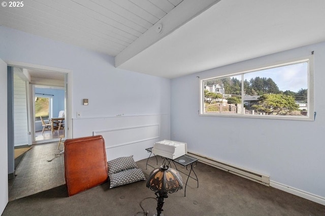 sitting room with beamed ceiling, a baseboard heating unit, and dark carpet