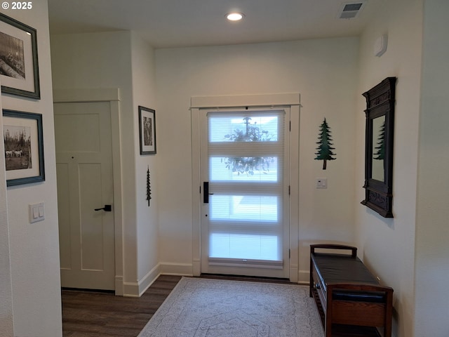 doorway featuring baseboards, visible vents, dark wood-style flooring, and recessed lighting