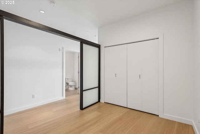 949 NW Overton St Unit 1007, Portland, OR 97209 - unfurnished bedroom with light wood-style floors, a closet, recessed lighting, and baseboards