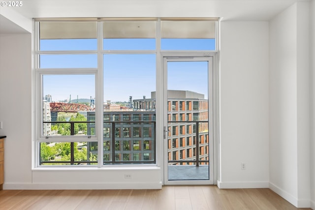 949 NW Overton St Unit 1007, Portland, OR 97209 - empty room featuring wood finished floors, a view of city, and baseboards