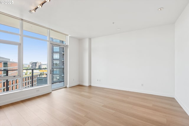 949 NW Overton St Unit 1007, Portland, OR 97209 - spare room featuring healthy amount of natural light, light wood finished floors, and baseboards