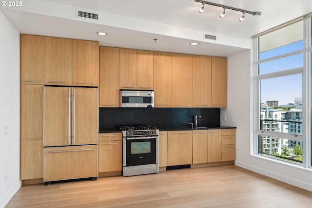 949 NW Overton St Unit 1007, Portland, OR 97209 - kitchen featuring appliances with stainless steel finishes, dark countertops, light wood-style floors, baseboards, and recessed lighting