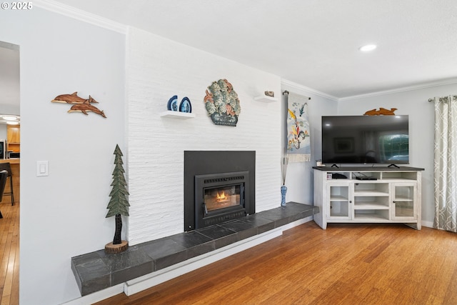 35111 Jefferson Ln, Astoria, OR 97103 - living room featuring wood finished floors, ornamental molding, a tiled fireplace, and recessed lighting