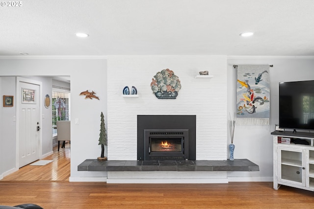 35111 Jefferson Ln, Astoria, OR 97103 - living room with wood finished floors, ornamental molding, a tile fireplace, and recessed lighting