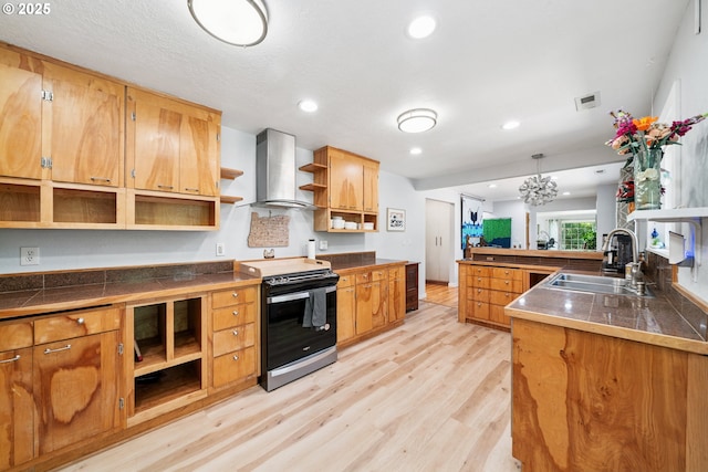 35111 Jefferson Ln, Astoria, OR 97103 - kitchen with open shelves, stainless steel range with electric stovetop, wall chimney range hood, light wood-style floors, and a peninsula