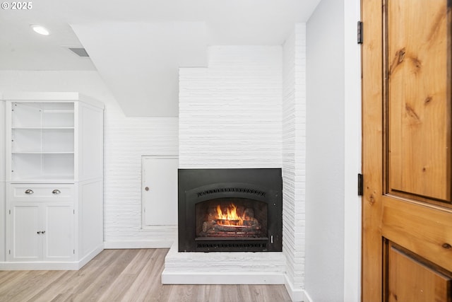35111 Jefferson Ln, Astoria, OR 97103 - detailed view of wood finished floors and a warm lit fireplace