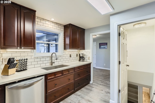 kitchen with sink, dark brown cabinets, dishwasher, light hardwood / wood-style floors, and backsplash