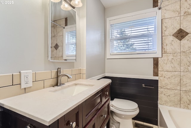 full bathroom with vanity, toilet, shower / washtub combination, and tile walls