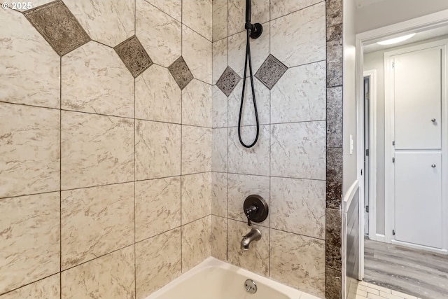 bathroom with tiled shower / bath and hardwood / wood-style floors