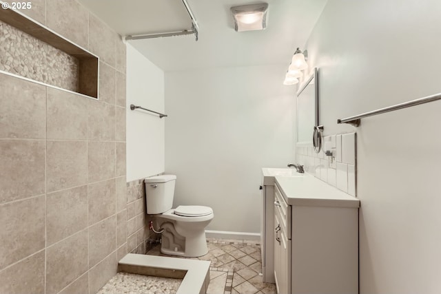 bathroom with vanity, decorative backsplash, and toilet