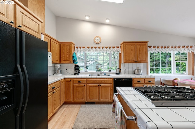 20 Wild Winds St, Florence, OR 97439 - kitchen with black appliances, lofted ceiling, light wood-style flooring, backsplash, and tile countertops