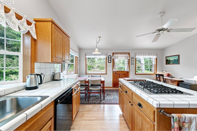 20 Wild Winds St, Florence, OR 97439 - kitchen featuring dishwasher, tile countertops, stainless steel gas cooktop, light wood-style floors, and ceiling fan