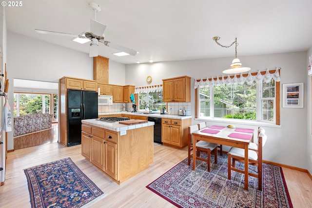20 Wild Winds St, Florence, OR 97439 - kitchen featuring black appliances, a center island, tasteful backsplash, a ceiling fan, and light wood-type flooring