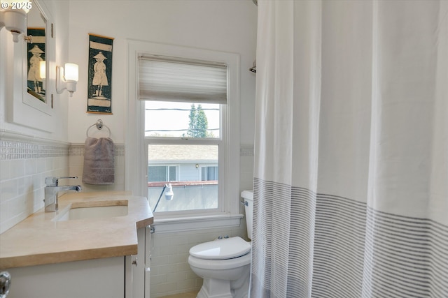 1534 NE 26th Ave Unit 8, Portland, OR 97232 - full bathroom with tile walls, toilet, plenty of natural light, vanity, and a wainscoted wall