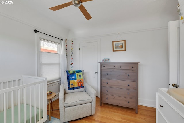 1534 NE 26th Ave Unit 8, Portland, OR 97232 - bedroom with a nursery area, light wood-type flooring, a ceiling fan, and baseboards