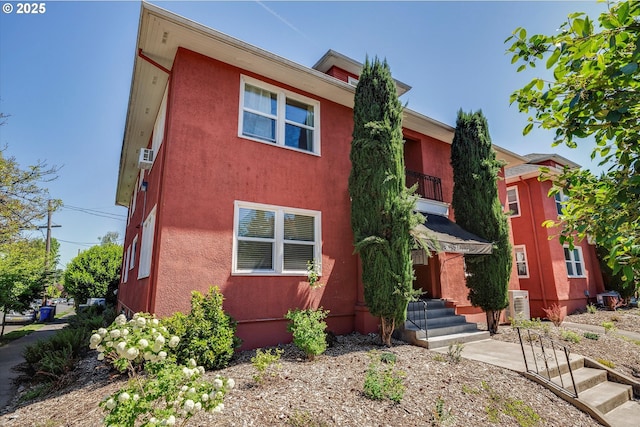 1534 NE 26th Ave Unit 8, Portland, OR 97232 - view of property featuring a balcony, stucco siding, and entry steps