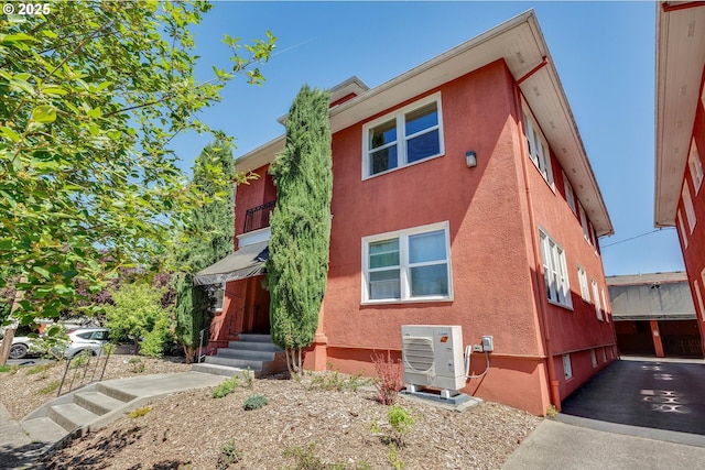1534 NE 26th Ave Unit 8, Portland, OR 97232 - townhome / multi-family property featuring a cooling unit, stucco siding, and entry steps