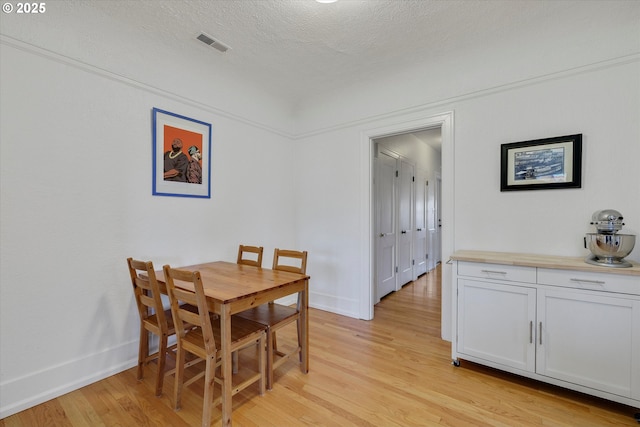 1534 NE 26th Ave Unit 8, Portland, OR 97232 - dining space with light wood finished floors, baseboards, and a textured ceiling